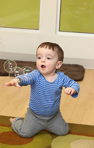 Infant chasing bubbles in our Sheldon infant program