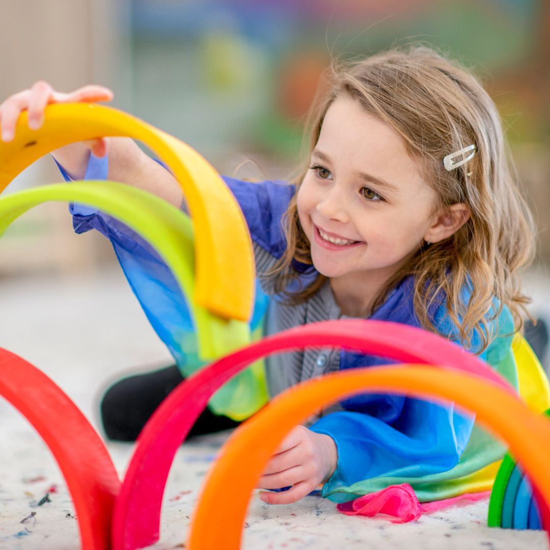 girl building with rainbow blocks